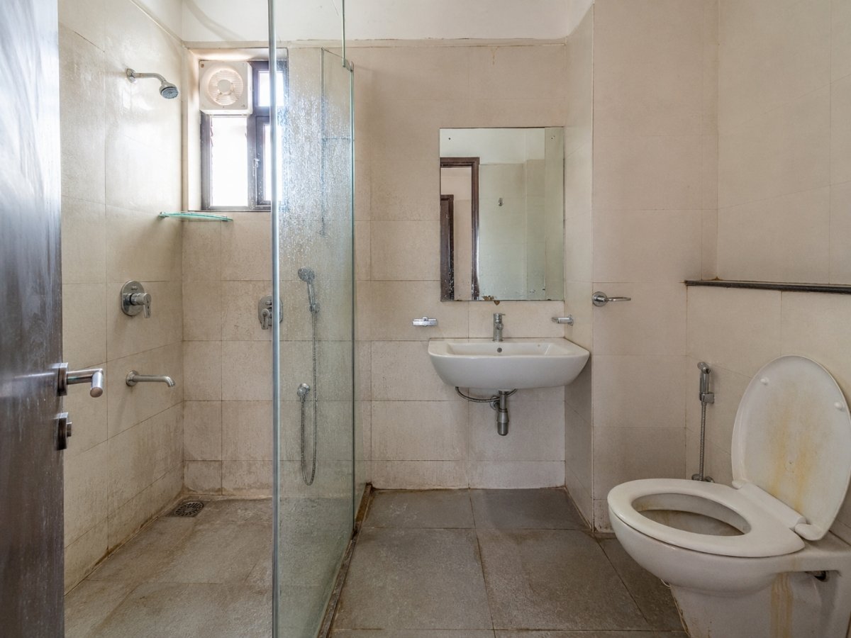 Bathroom with hard water stains before a deep clean in Tumkur